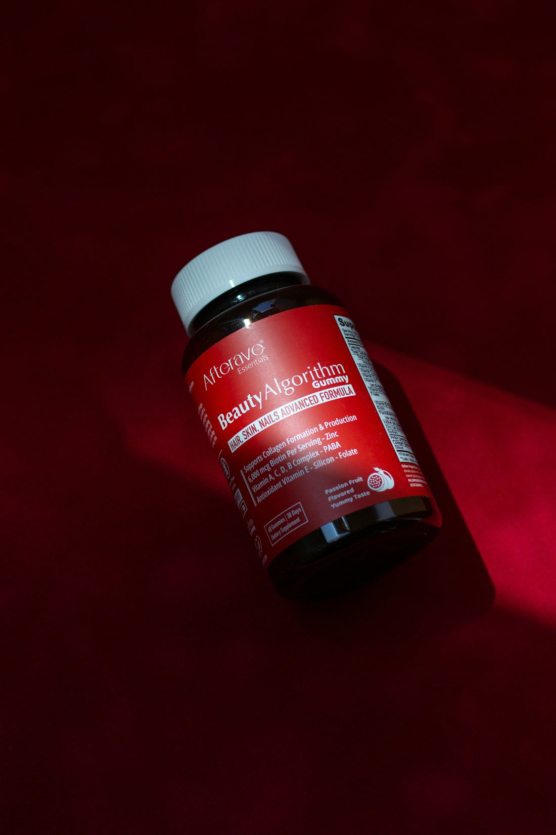 A bottle of vitamins on a red surface
