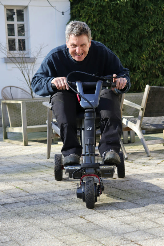 Man riding a mobility scooter with a smile