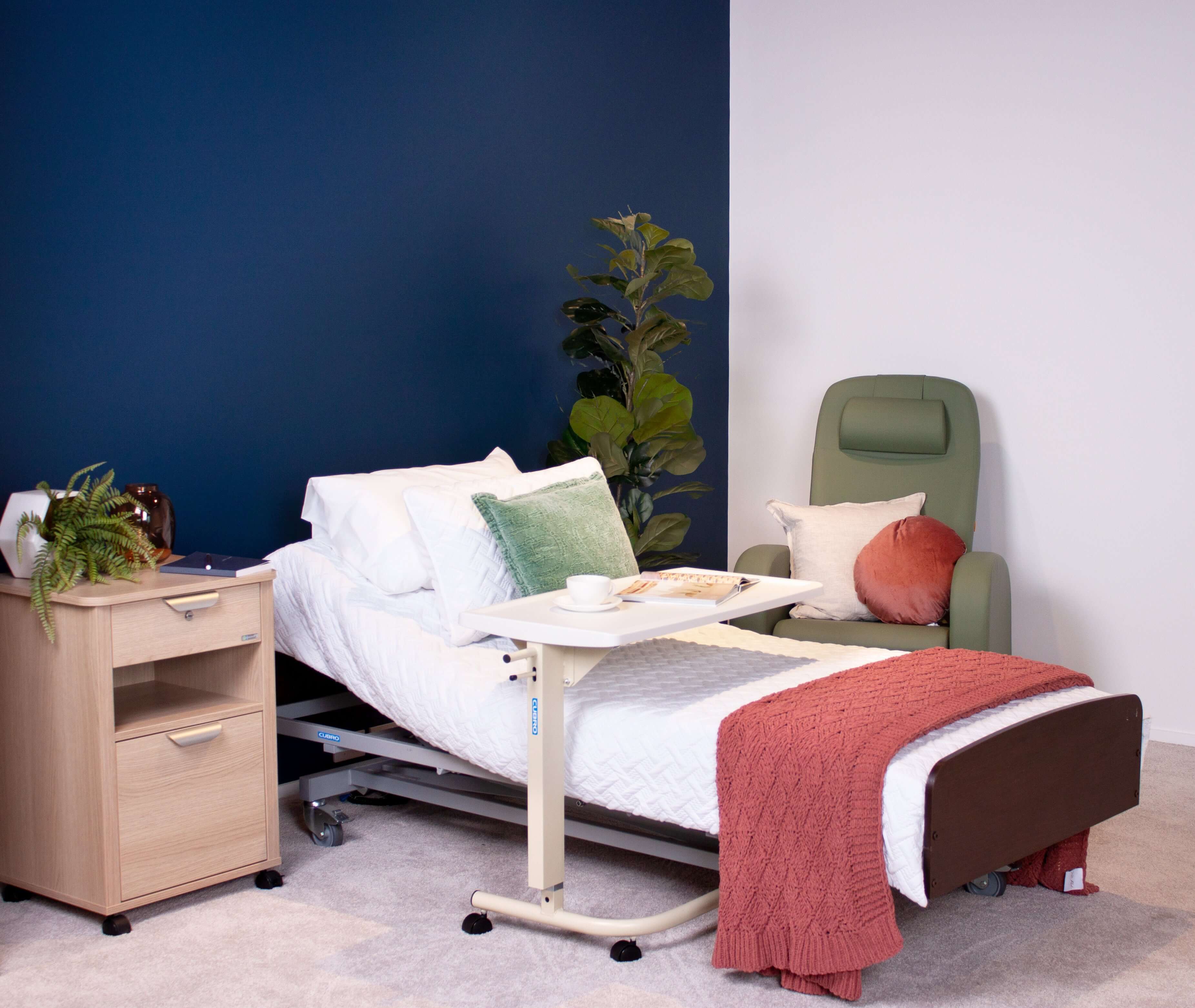 Adjustable electric bed in a modern home care setup with nightstand and cozy chair.