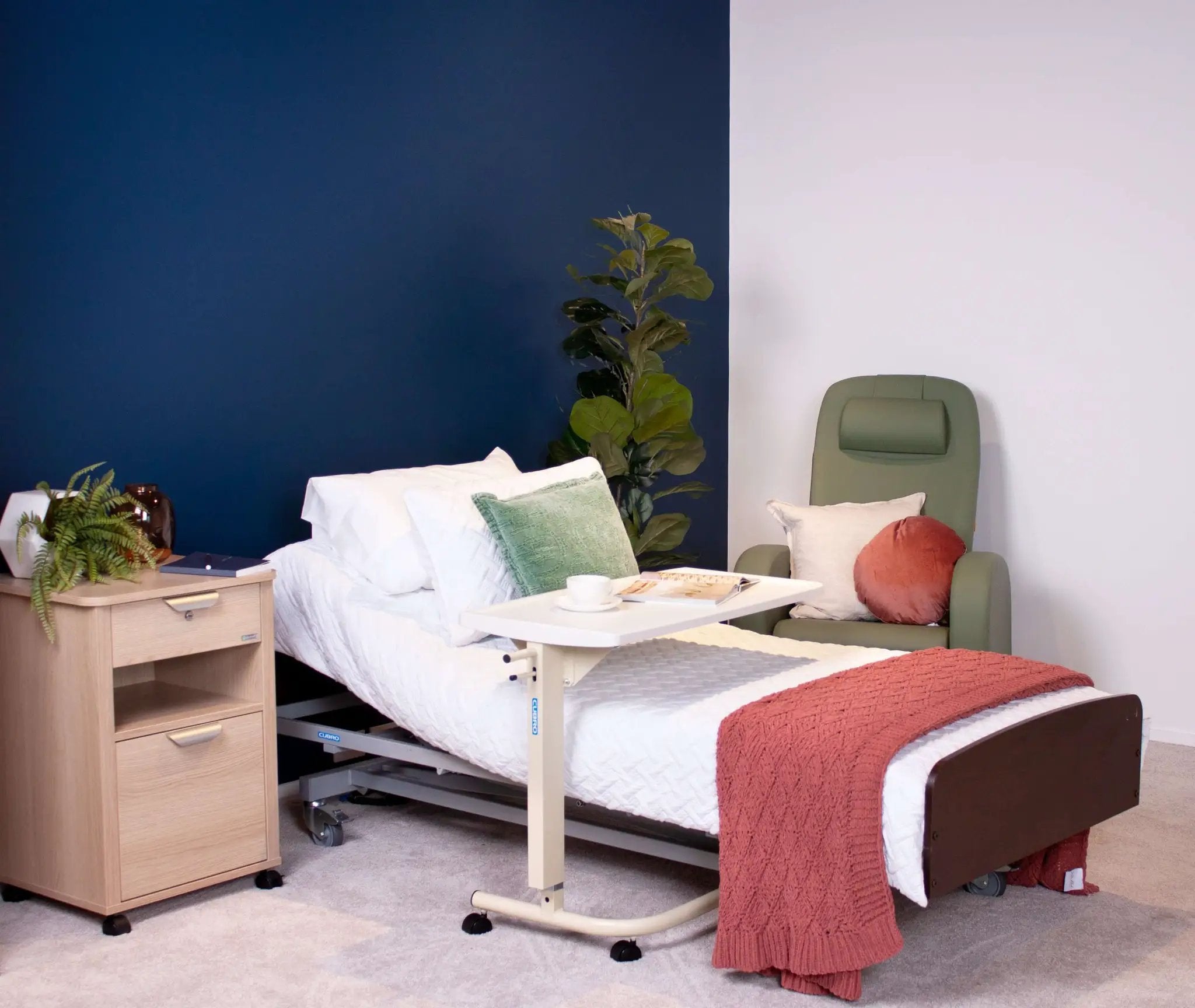 Adjustable electric bed in a modern home care setup with nightstand and cozy chair.