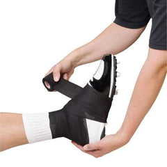 Mueller lightweight spatting tape securing a cleat on a player's foot during sports preparation.